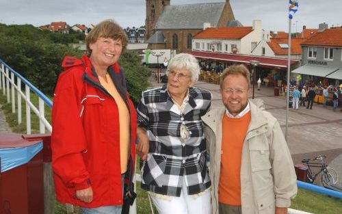 ZOUTELANDE â€“ Ds. Thomas Stockkamp (r.) samen met zijn vrouw (l.) en de Zoutelandse S. Adriaanse (m.) op de boulevard van Zoutelande. De predikant uit de Duitse stad Krefeld verzorgt ’s zomers Duitstalige kerkdiensten in de hervormde dorpskerk van Zoutel