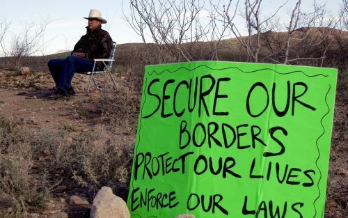 SAN DIEGO â€“ Een Amerikaanse vrijwilliger houdt de grens met Mexico in de gaten om te voorkomen dat illegale immigranten zijn land binnenkomen. Foto EPA