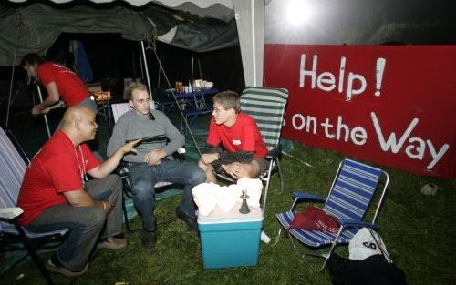 BIDDINGHUIZEN â€“ Jongeren bij een evangelisatietent in gesprek met een bezoeker van het muziekfestival Lowlands in Biddinghuizen. De slogan van het evangelisatieproject was: ”Help!... is on the Way”. Foto ANP