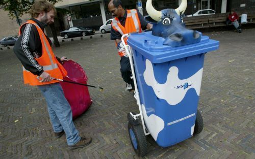 ROTTERDAM â€“ Deelnemers aan een hulpverleningsproject voor onder meer bedelaars reden zaterdag met zogeheten koeiencontainers door de Rotterdamse binnenstad. Daarmee zamelen ze op straat zwerfvuil in. De â€˜koe’ gaat loeien als het deksel opengaat. Foto 