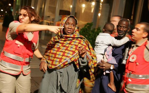 PARIJS â€“ Medewerkers van het Franse Rode Kruis evacueren slachtoffers van de brand in een appartementencomplex in Parijs. In de vuurzee kwamen de afgelopen nacht zeker zeventien mensen, voornamelijk Afrikaanse immigranten, om het leven. Foto ANP