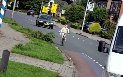 RIJSSEN â€“ Een jongetje fietst tussen de auto’s over de Nijverdalseweg in Rijssen. De straat moet weer veiliger worden voor kinderen, vinden politici, beleidsmakers, ouders en stedebouwkundigen uit 22 landen. Ze overlegden de afgelopen dagen met elkaar i