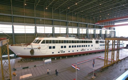 KINDERDIJK â€“ Vanuit de montagehal van IHC Holland Dredgers in Kinderdijk komt het nieuwe cruiseschip van stichting de Zonnebloem zaterdagmiddag in zijn element. Het 115 meter lange casco van De Zonnebloem â€“de naam staat er al opâ€“ glijdt om kwart voo