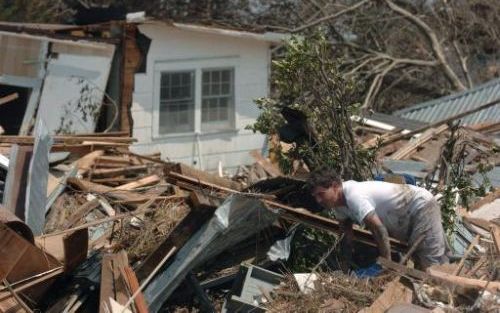 BILOXI - Cameron Sweet zoekt, temidden van de puinhopen van zijn huis naar zijn kat. Volgens president Bush zal het herstel van de schade na de orkaan Katrina jaren duren. Foto: EPA