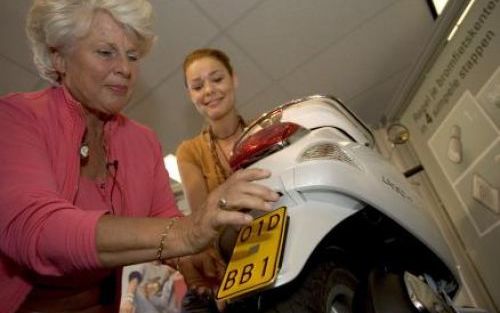 GOUDA - Minister Peijs van Verkeer plaatst donderdag in Gouda het eerste kenteken voor bromfietsen van Nederland op een scooter. Als het aan minister Peijs (Verkeer) ligt, raken bestuurders die op hun bromscooters rondcrossen al bij de eerste de beste ver