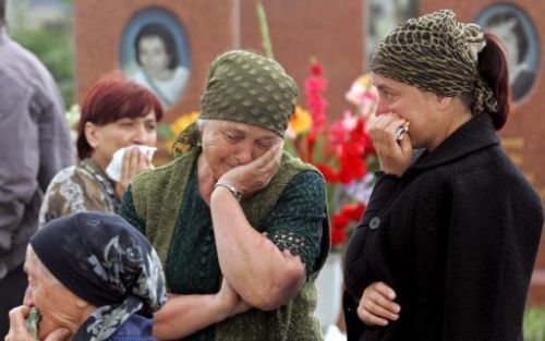 BESLAN - Vrouwen huilen bij de graven waar kinderen liggen die vorig jaar omkwamen bij de gijzeling in Beslan. Foto EPA