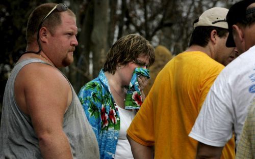 NEW ORLEANS â€“ Een vrouw die wordt omringd door reddingwerkers, wordt gevraagd het lichaam van een van haar buren te identificeren. De man werd gevonden tussen de puinhopen van zijn huis. Foto EPA