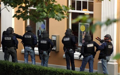 ENSCHEDE: Een arrestatieteam gaat de SNS Bank aan de Tromplaan in Enschede binnen. ANP FOTO