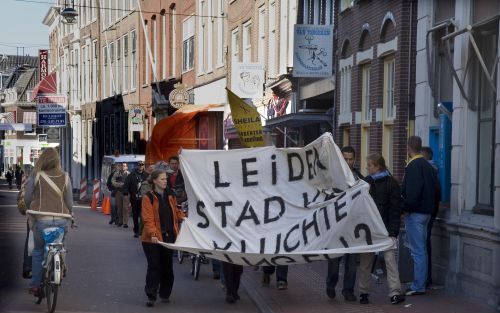 LEIDEN â€“ Leden van de Kraakgroep Leiden lopen in optocht van de Leonarduskerk naar het stadhuis. Samen met de Socialistische Partij Leiden, Stichting de Fabel van de illegaal en Pastoraal Werk Leiden Noord willen zij in de kerk een opvangtehuis voor dak