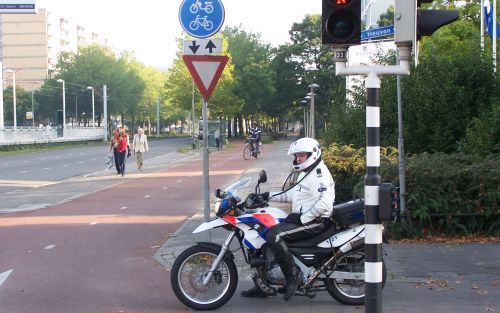 UTRECHT â€“ Een motoragent van het Utrechtse straatroofteam houdt een kruising bij de probleemwijk Kanaleneiland in de gaten. Automobilisten die voor een verkeerslicht staan te wachten, worden regelmatig bestolen door jonge straatrovers die vanaf de scoot