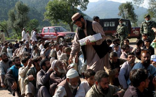 BARAKOT â€“ Vrachtwagens volgeladen met vluchtelingen in het rampgebied in Pakistan. Foto Kjeld Duits