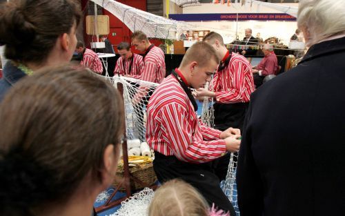 UTRECHT â€“ De eerste bezoekers van Wegwijs kijken naar de vervaardiging van visnetten. De vissersplaats Urk presenteert zich uitgebreid op een van de themapleinen. De gezinsbeurs in de Utrechtse Jaarbeurs is dinsdagmorgen van start gegaan. Foto RD, Anton