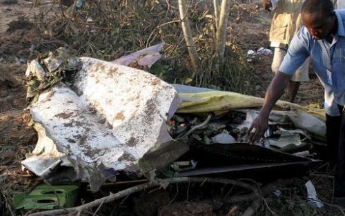 LISSA - Een Nigeriaanse reddingswerker bij een wrakstuk van de neergestorte Boeing 737. Het vliegtuig stortte zaterdagavond neer, alle 117 inzittenden kwamen om het leven. Foto EPA