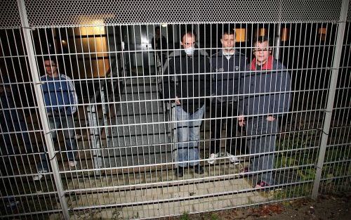 SCHIPHOL - Gevangenen van het cellencomplex op Schiphol-Oost staan buiten tijdens de brand, een enkele met een mondkapje tegen de rook. Foto ANP