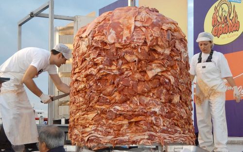 PATRA â€“ Medewerkers van een restaurant in het Griekse Patra maken een enorme hoeveelheid kebab klaar. Zij hopen met het 2000 kilo zware gevaarte een plaats in het Guinness Book of Records te veroveren. Foto EPA