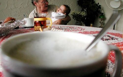 Oma past op de kleinkinderen; het is een oplossing die nogal eens gekozen wordt als moeder in deeltijd wil of moet gaan werken. Foto ANP