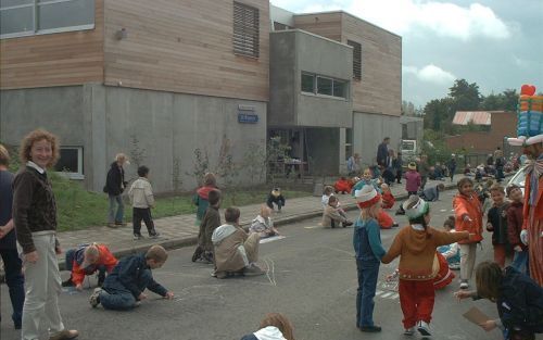 Leerlingen van School met de Bijbel de WEGwijzer in Mechelen spelen tijdens de straatspeeldag met stoepkrijt. Foto de WEGwijzer.