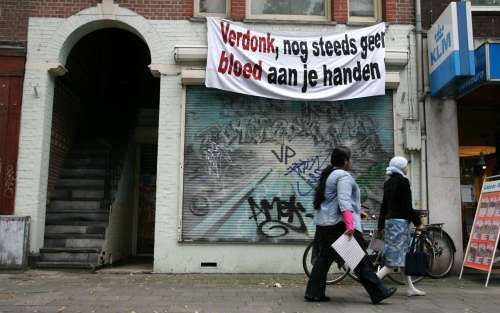 AMSTERDAM - Bewoners van een huis aan de Bilderdijkstraat in Amsterdam hebben een spandoek aan de gevel gehangen naar aanleiding van de brand in het cellencomplex op Schiphol-Oost. Op last van de politie werden zaterdag alle spandoeken met teksten gericht