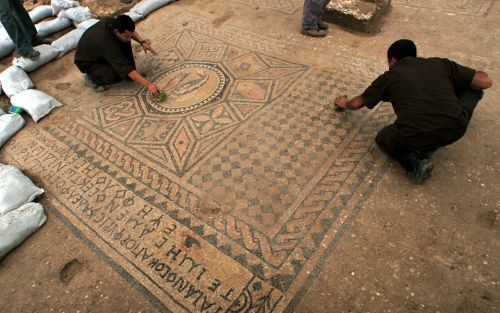 MEGIDDO â€“ Gevangenen reinigen een mozaÃ¯ek van een vis, omringd door geometrische patronen. De IsraÃ«lische Oudhedendienst heeft op het terrein van een zwaarbewaakte gevangenis mogelijk de oudste kerk in IsraÃ«l ontdekt. De ruimte meet zes bij negen met