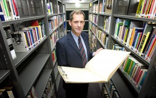 UTRECHT â€“ Drs. Aart Verburg met een â€˜stamboek’ van de honderdjarige zendingsopleiding in zijn hand. Het bevat de gegevens van alle studenten en cursisten van het Hendrik Kraemer Instituut sinds 1905. - Foto Hans Roggen