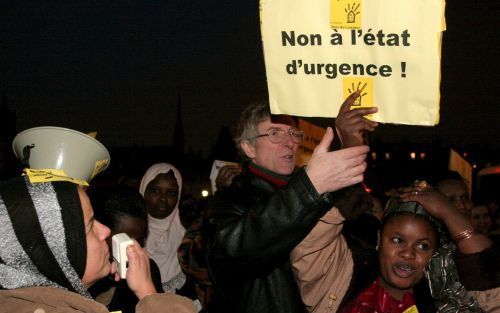 PARIJS â€“ ”Nee tegen de noodtoestand” meldt een bord. Honderden Fransen demonstreerden zaterdag in Parijs tegen de maatregelen die de regering heeft afgekondigd om de aanhoudende onlusten in de voorsteden te beteugelen. Foto EPA