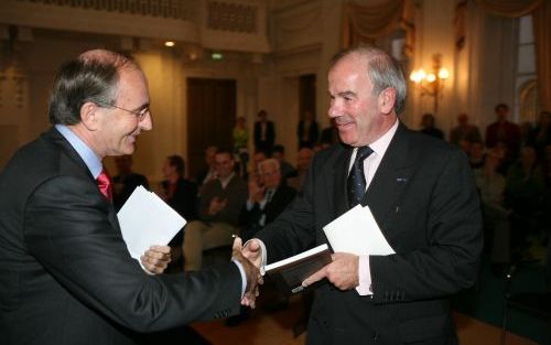 DEN HAAG â€“ Kamervoorzitter Weisglas (r.) kreeg dinsdag het boek ”God in de Nederlandse politiek” overhandigd door mr. E. M. d’Hondt, bestuursvoorzitter van de Stichting Parlementaire Geschiedenis. Weisglas viel minister Zalm bij in de strijd die hij bij