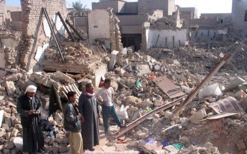 FALLUJAH â€“ Inwoners van Fallujah kijken naar de ravage die gevechten tussen Amerikaanse troepen en Iraakse opstandelingen in november 2004 aanrichtten. Een jaar na de bloedige confrontatie komt de wederopbouw van de Iraakse stad nog maar langzaam van de