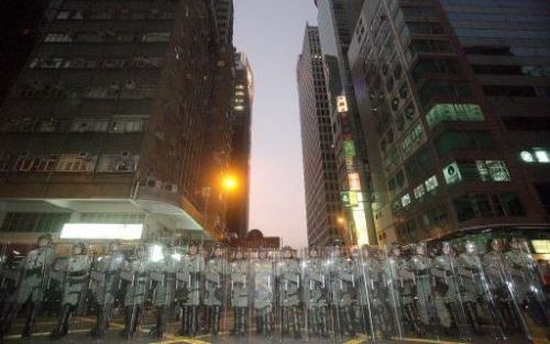 HONGKONG - Politiemannen vormen een cordon om demonstranten tegen te houden. Foto EPA