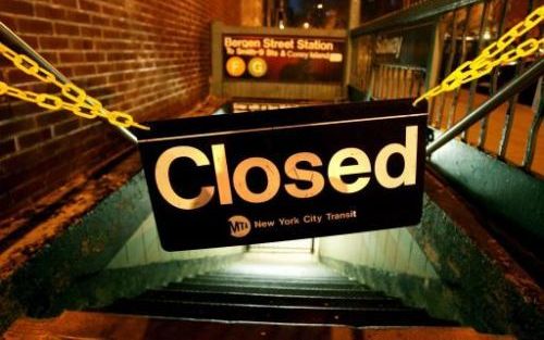 Een bordje met '”Gesloten" erop hangt voor een metro-ingang in New York. Het openbaar vervoer in de Amerikaanse stad New York ligt dinsdag plat door een grote staking. Foto EPA