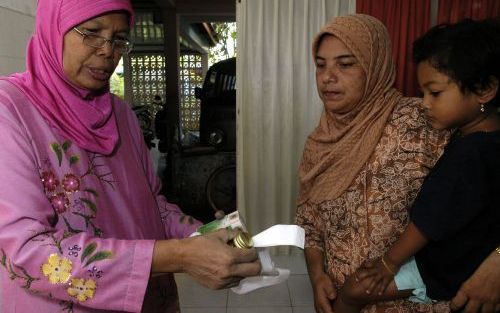 BANDA ATJEH â€“ Dokter Rachmadi van de Wereldgezondheidsorganisatie (WHO) praat in een kliniek in Banda Atjeh met een moeder over de verschijnselen van malaria. Foto Kjeld Duits