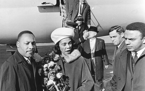 SCHIPHOL â€“ Ds. Martin Luther King (l.) komt in 1965 samen met zijn vrouw aan op Schiphol voor de inontvangstname van een eredoctoraat in de sociale wetenschappen aan de Vrije Universiteit te Amsterdam. Maandag werd in de Verenigde Staten voor de twintig