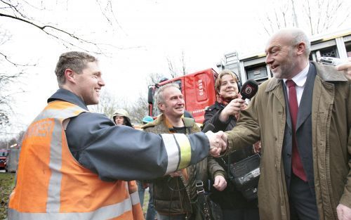 EINHOVEN - Een automobilist uit Leende wordt door de brandweer gefeliciteerd nadat hij uit zijn auto is bevrijd. De auto waarin raakte onder een tankwagen die vrijdagmorgen op de A67 van het talud reed. Foto ANP