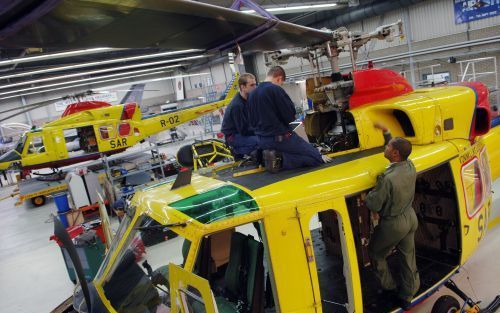 LEEUWARDEN â€“ Technici zijn bezig met grootschalig onderhoud aan een SAR helikopter (Search and Rescue) op vliegbasis Leeuwarden. Op de achtergrond staat een tweede heli klaar om uit te rukken. Tijdens oefeningen staat er op Vlieland een derde toestel st