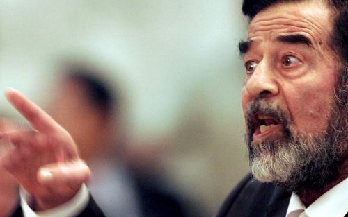 BAGDAD â€“ Saddam Hussein in discussie met de nieuwe rechtbankvoorzitter Raouf Abdel Rahman. De Iraakse ex-president verliet zondag de rechtszaal nadat de zitting van zijn rechtszaak op een totale chaos was uitgelopen. Foto EPA