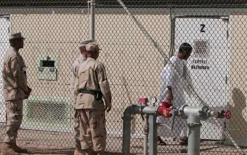 Bewakers praten met een gevangene in detentiekamp GuantÃ namo Bay. Foto EPA