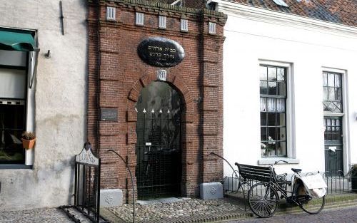 ELBURG â€“ Een poortje, ineengeklemd tussen andere historische pandjes in Elburg, geeft toegang tot wat vroeger de binnenplaats van de synagoge was. Boven de poortingang zit een bord op de muur met een Hebreeuwse inscriptie: „Wij wandelen in gezelschap te