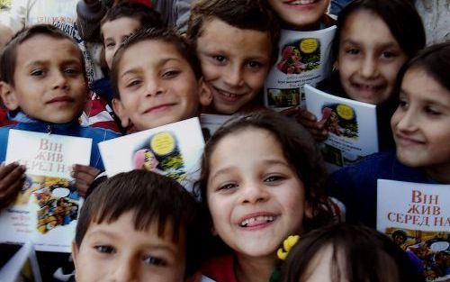 LUTSK â€“ Zigeunerkinderen uit OekraÃ¯ne tonen trots een exemplaar van ”Hij leefde onder ons”. Foto RD