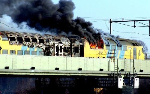 ZWOLLE - Vlammen en dikke rookwolken komen maandag uit een trein bij de IJsselbrug bij Zwolle. Foto ANP