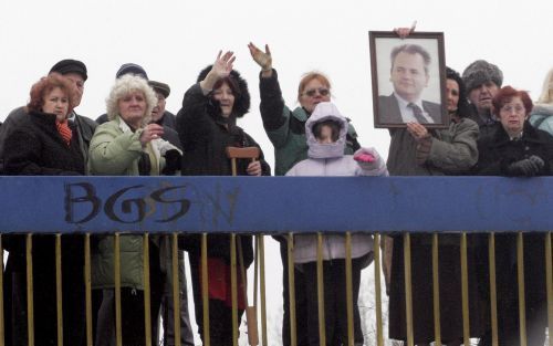 BELGRADO - Symphatisanten zwaaien naar de rouwauto waarin het lichaam van Milosevic wordt vervoerd. De oud-president wordt zaterdag begraven in zijn woonstad Pozarevac, ten zuiden van Belgrado. Foto EPA.