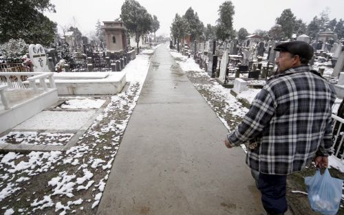 POZAREVAC - Een beheerder van een begraafplaats in Pozarevac loopt woensdag langs de graven. Milosvic, die op 11 maart is overleden in zijn cel in Den Haag zal worden begraven in de tuin van het familielandgoed in Pozarevac. Foto EPA