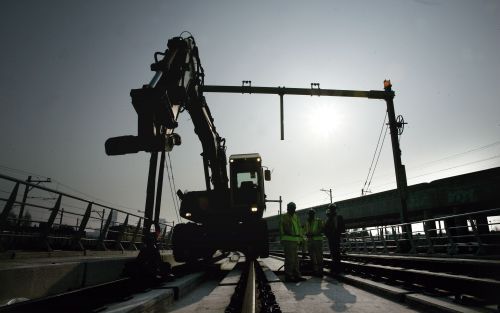 ROTTERDAM â€“ Een kraan brengt de laatste 30 meter rails op z’n plaats. Tussen Blijdorp en Rotterdam Centraal werd vrijdag het noorddeel van de HSL Zuid aan het zuidelijk tracÃ©deel gekoppeld. De thermische las had plaats in een mal. Staal en aluminium wo