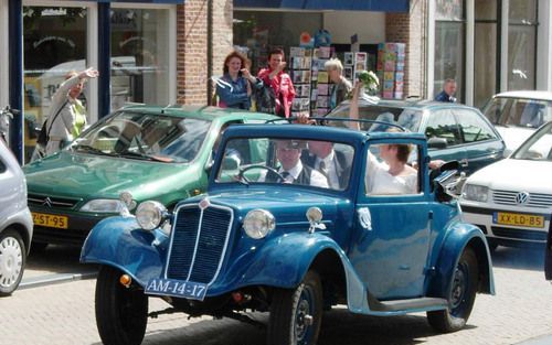 Nog maar Ã©Ã©n dag op kenteken en nu al trouwauto: Romke van Groning stuurt zijn Tatra 57A cabriolet door Franeker, met achterin zijn zus Japke en haar kersverse echtgenoot Martijn. Foto FD, Frans Andringa