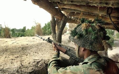 INDIA - Een Indiase soldaat kijkt vanuit zijn bunker naar mogelijke vijanden vlakbij de grens met Pakistan. - Foto EPA