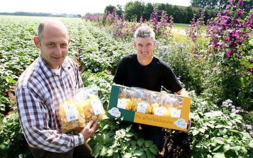 ’s GRAVENDEEL â€“ Wat begon als grapje is inmiddels serieuze handel. Foto: De Zeeuw en Scheele (r.) met hun Hoeksche Chips in een aardappelveld. Hoeksche Chips zijn wel beduidend duurder dan gewone. De Zeeuw: „We bakken op een ambachtelijke manier. Zie he