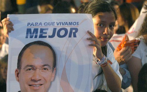 MEXICO CITY - Een aanhanger van presidentskandidaat CalderÃ³n, houdt een poster van haar held omhoog. Foto EPA