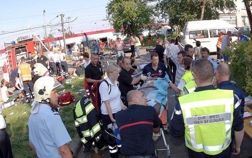 LUXEMBURG - Reddingswerkers helpen een gewonde man. Bij de treinbrand zijn zeker 31 mensen gewond geraakt. Foto EPA