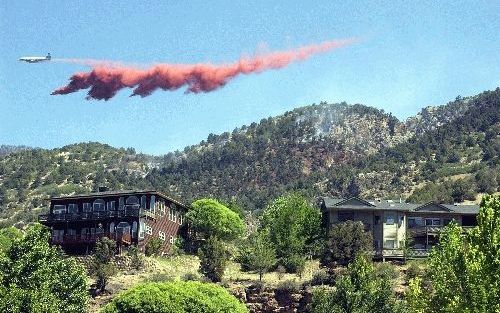 DENVER - Rookwolken vertonen zich dreigend achter de heuvels die de Amerikaanse stad Denver nog scheiden van enorme bosbranden. Omdat de vuurzee nog niet tot stilstand is gebracht, zijn begin deze week zo’n 40.000 inwoners in de buitenwijken van de stad o