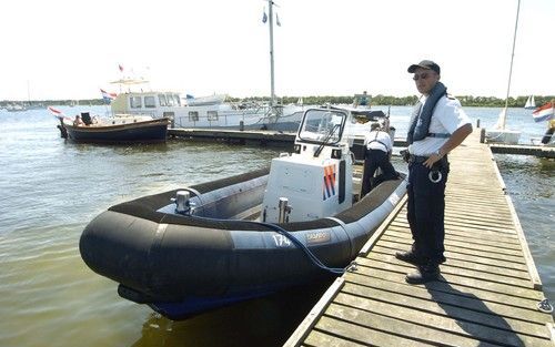 HARINGVRETER â€“ Maarten Platje (r.) en zijn collega John Davidse van de waterpolitie leggen aan bij het eiland de Haringvreter in het Veerse Meer. In de zomermaanden controleert de politie op wildkampeerders op het onbewoonde eiland. Foto Willem Woznitza