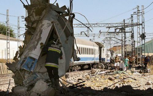 PALENCIA - Een brandweerman inspecteert een totaal verwrongen treinstel. Foto EPA