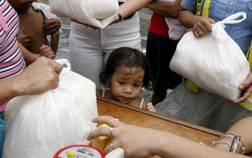 MANILA - Mensen staan in de rij voor hulpgoederen na tyfoon Xangsane. Foto EPA